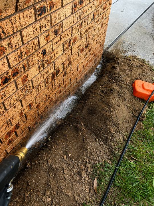 Chemical soil barrier applied along a brick footing